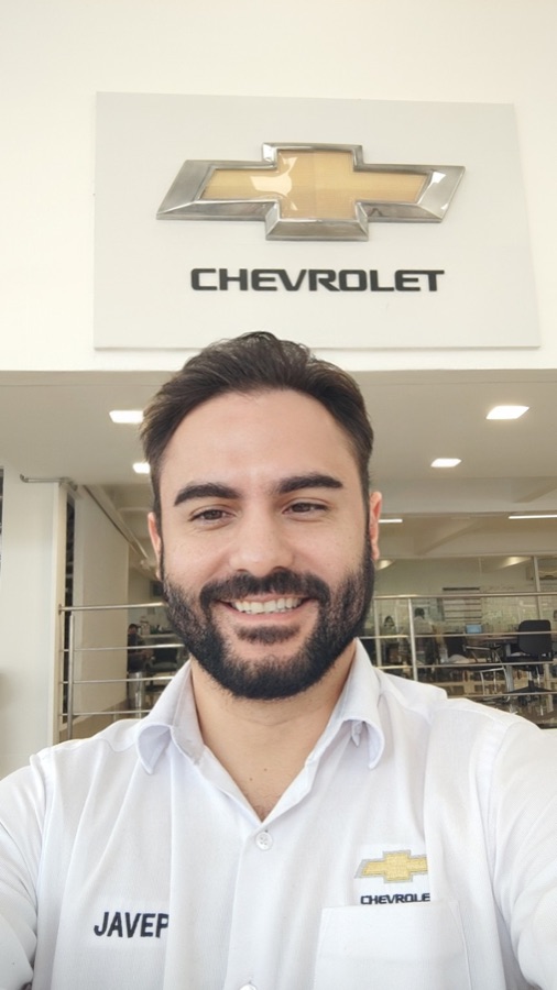 Anderson Rodrigues em frente ao logo Chevrolet na concessionária em Araçatuba